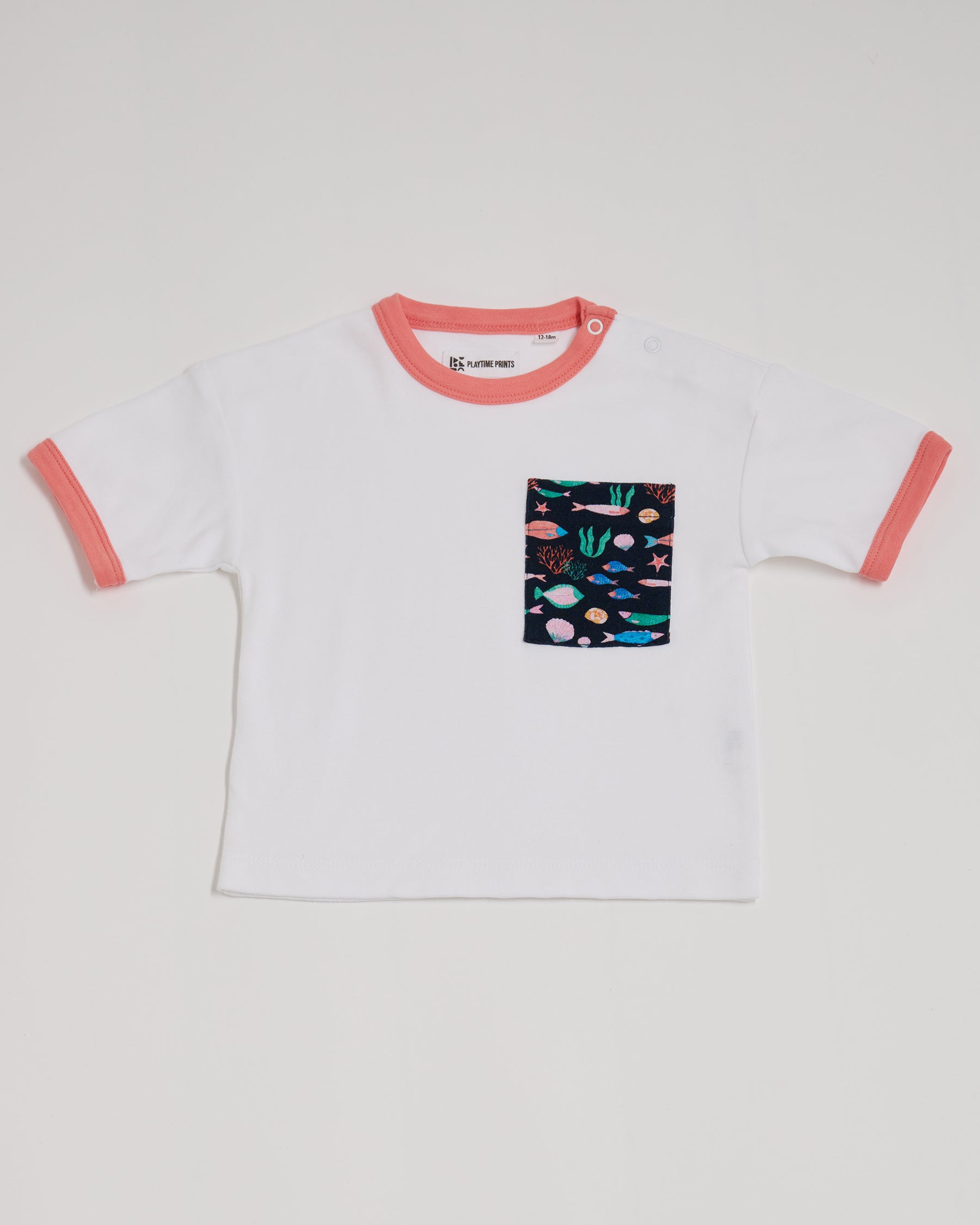 Front of white short sleeved  t-shirt with vibrant fish print square chest pocket, neck poppers and coral neck and sleeve trim.