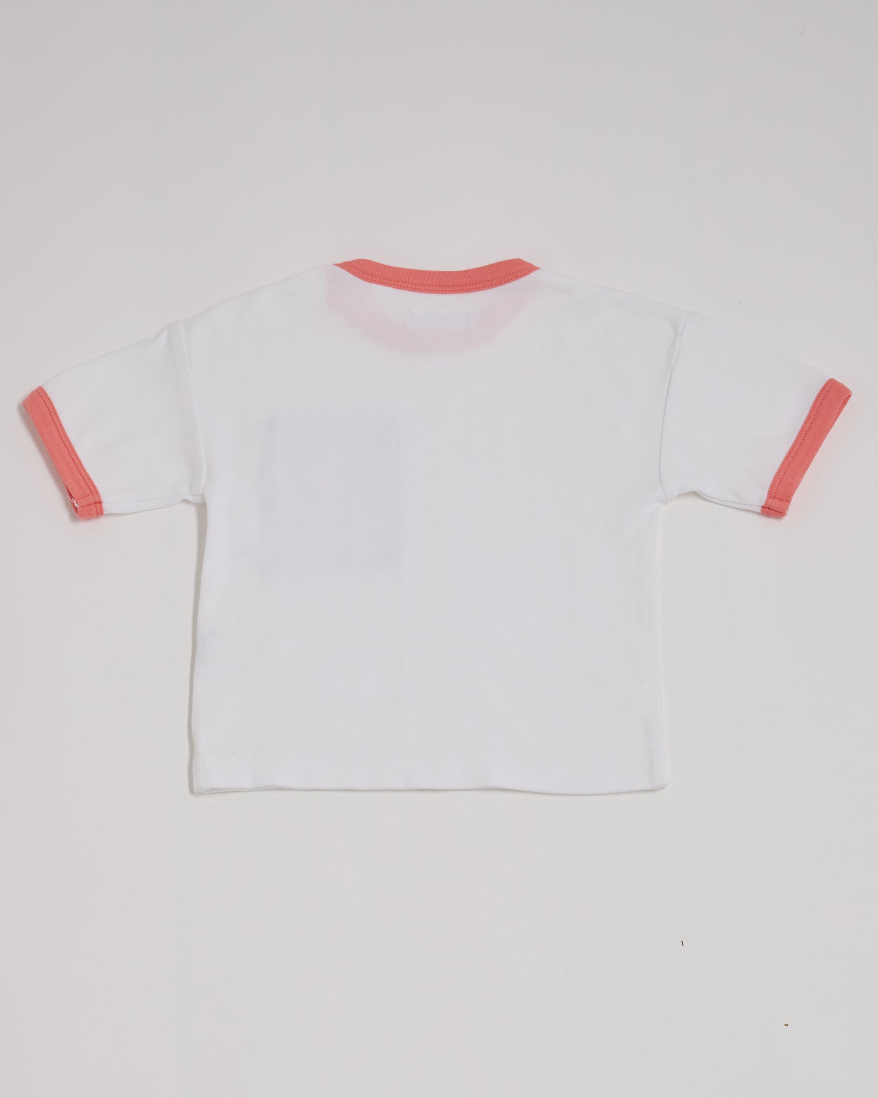 Back of white short sleeved t-shirt with coral neck and sleeve trim.