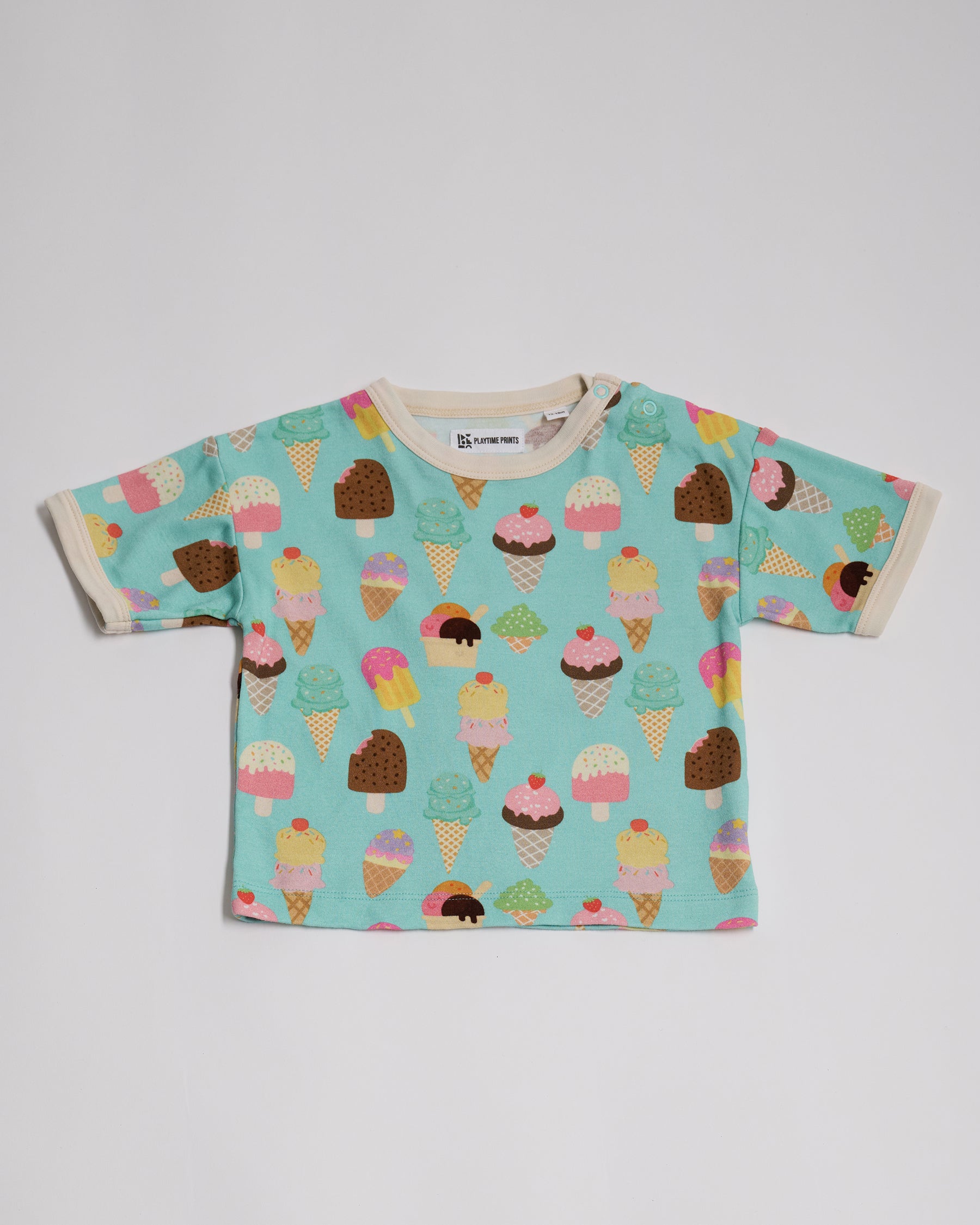 Front of short sleeved t-shirt featuring an all over turquoise ice cream print, contrast ecru neck and sleeve trim and neck poppers.