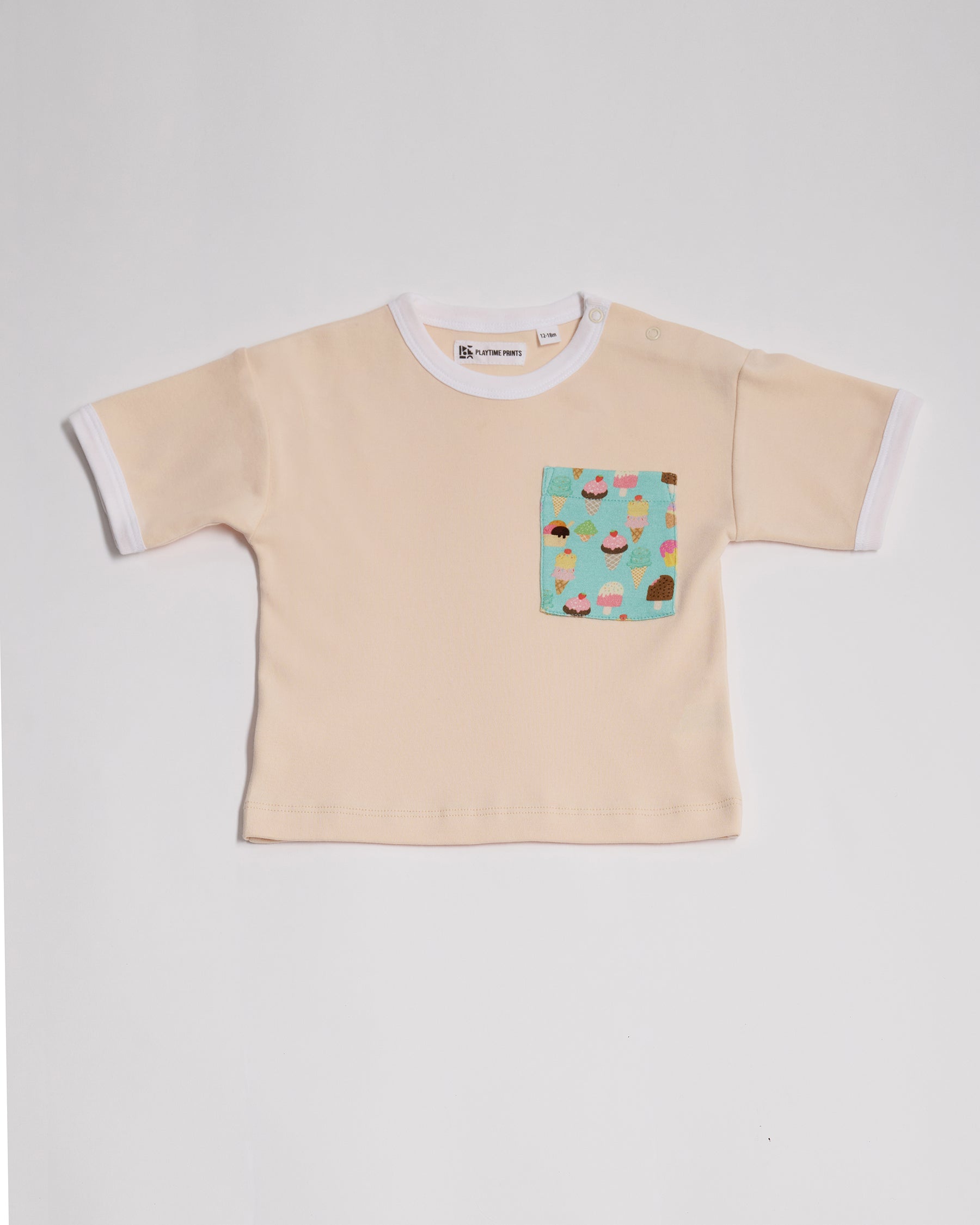 Front of vanilla coloured short sleeved t-shirt with bright ice cream print square chest pocket, neck poppers and white neck and sleeve trim.