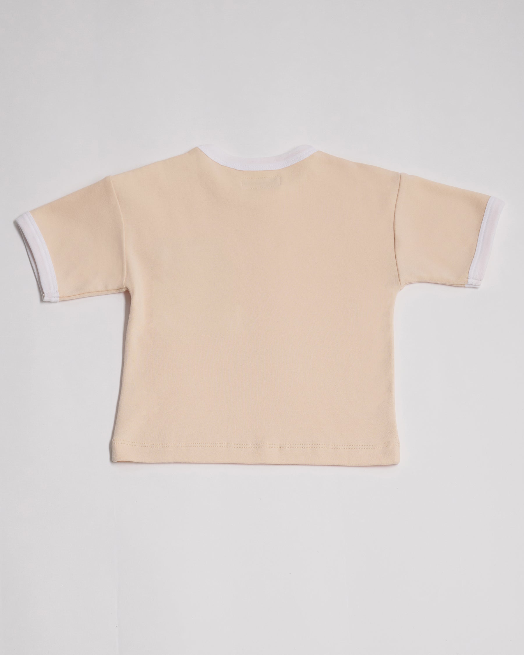 Back of vanilla coloured short sleeved t-shirt with white neck and sleeve trim.