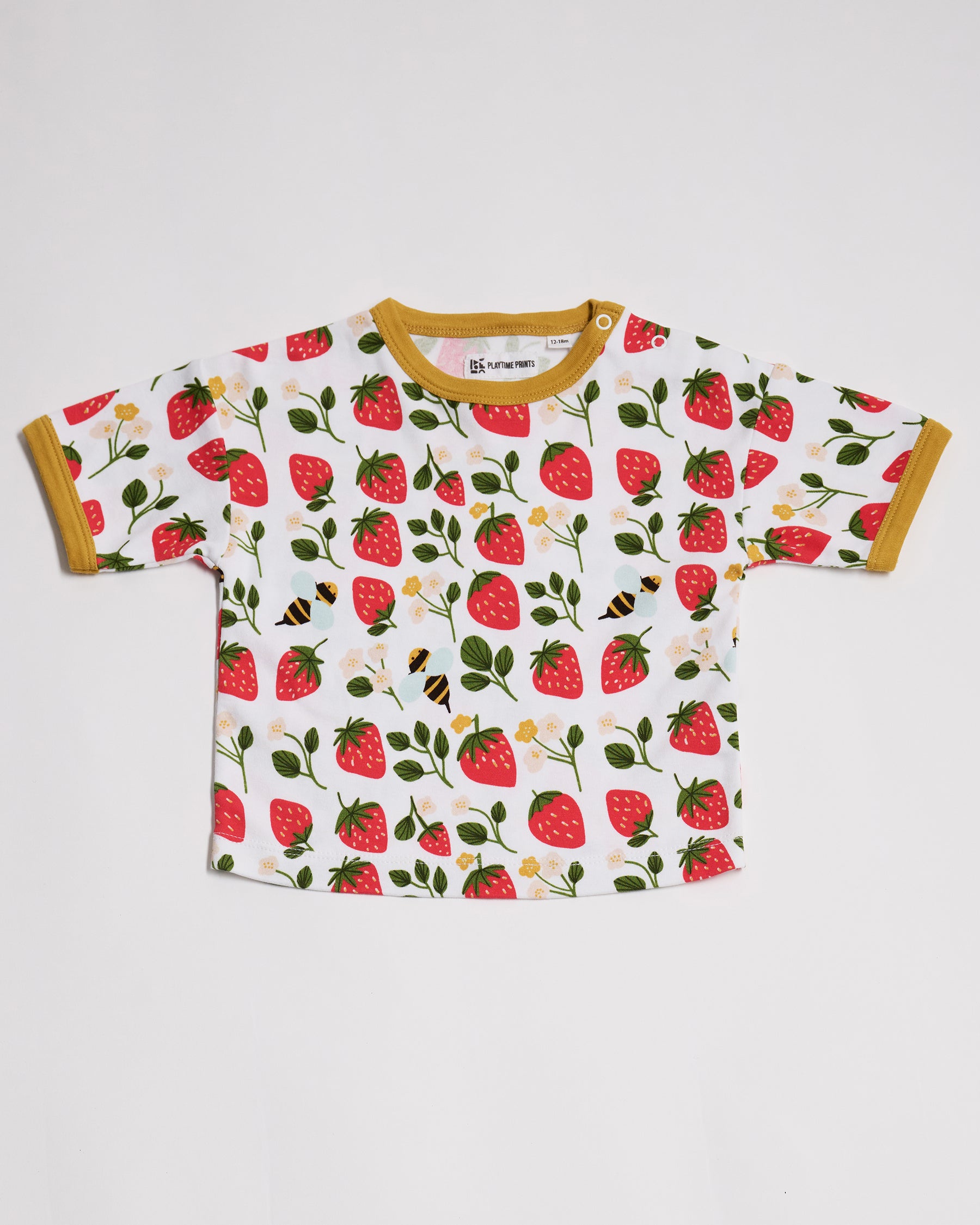 Front of short sleeved t-shirt featuring an all over strawberry and bees print, contrast honey neck and sleeve trim and neck poppers.
