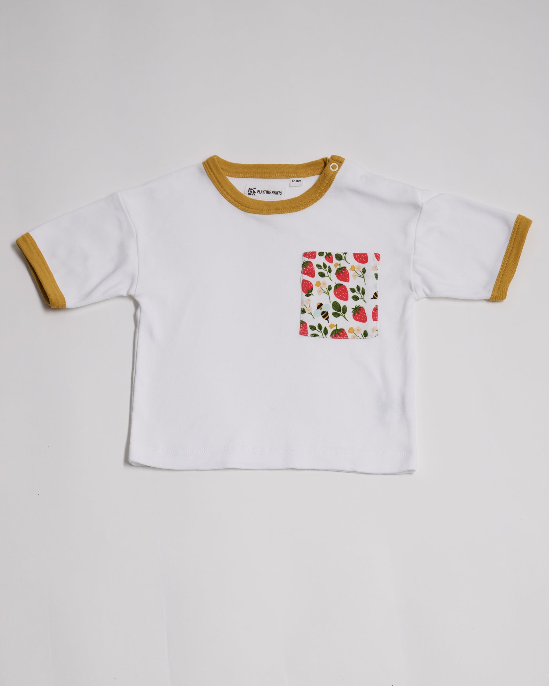 Front of white short sleeved  t-shirt with fun strawberry and bees print square chest pocket, neck poppers and honey neck and sleeve trim.