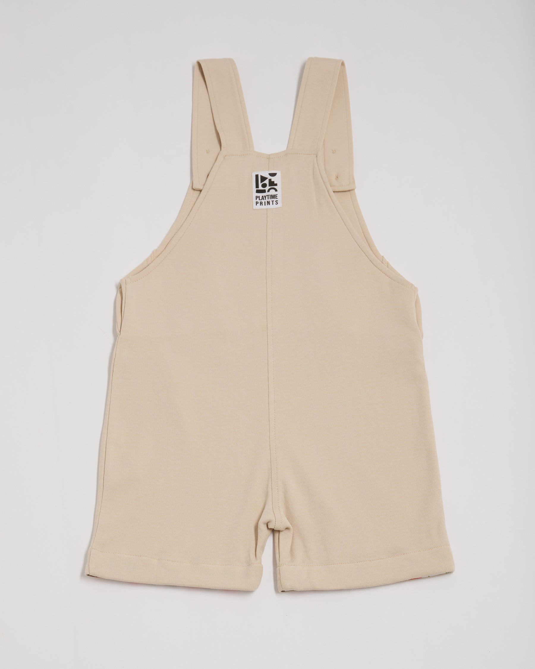 Back of beige short dungarees with Playtime Prints brand label.