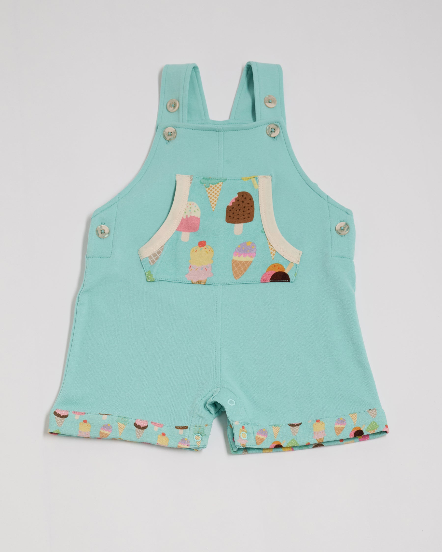 Front of turquoise short dungarees with bright ice cream print pocket and fixed turn-ups, adjustable straps, crotch poppers, vanilla buttons and vanilla trim.